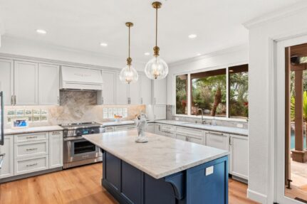 Completed kitchen renovation with white cabinetry and a blue island